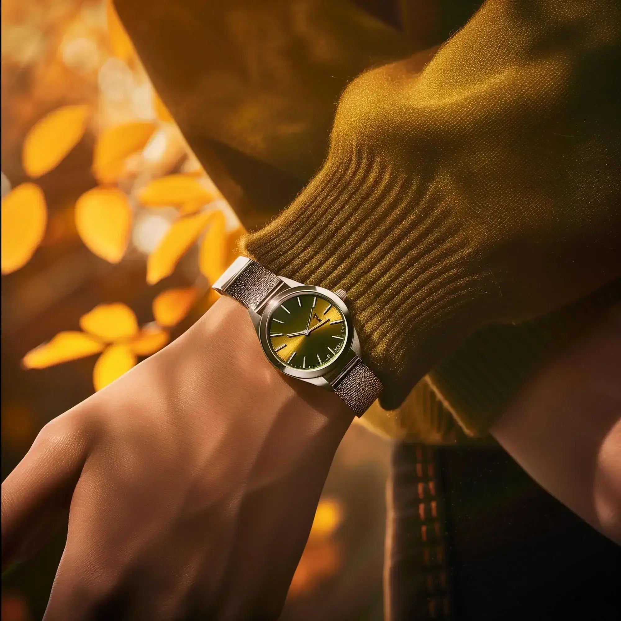 Hand wearing a watch with a blurred autumn background